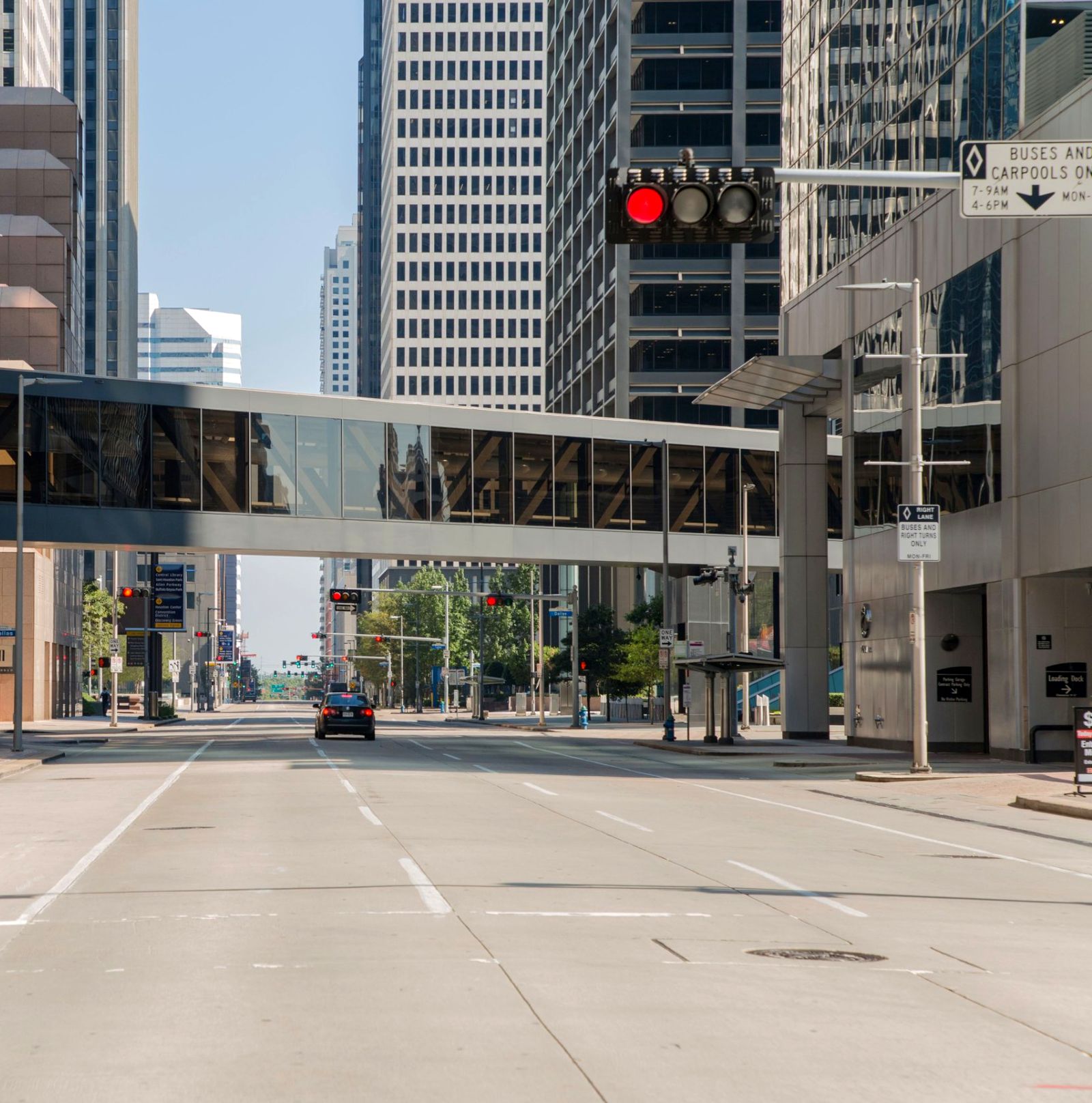 A quiet downtown Houston street with a glass skybridge